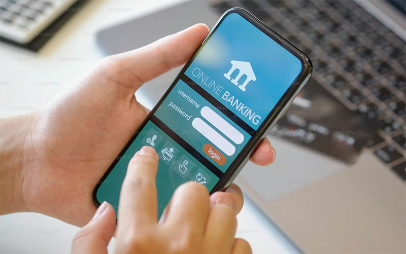 Person logging into an online banking app on a smartphone, representing mortgage and financing research for Twin Cities home buyers