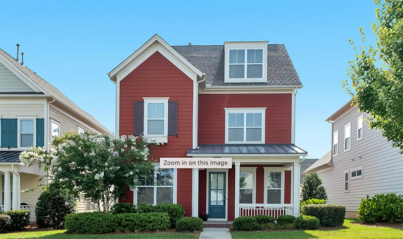 Two-story red craftsman-style home with white trim, dark shutters, a covered front porch, and a dormer window, representing a typical single-family home for sale in Minnesota