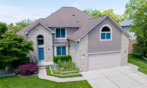 Two-story brick and shake siding home with a two-car garage, arched entryway, and landscaped front yard representing a typical Twin Cities residential property